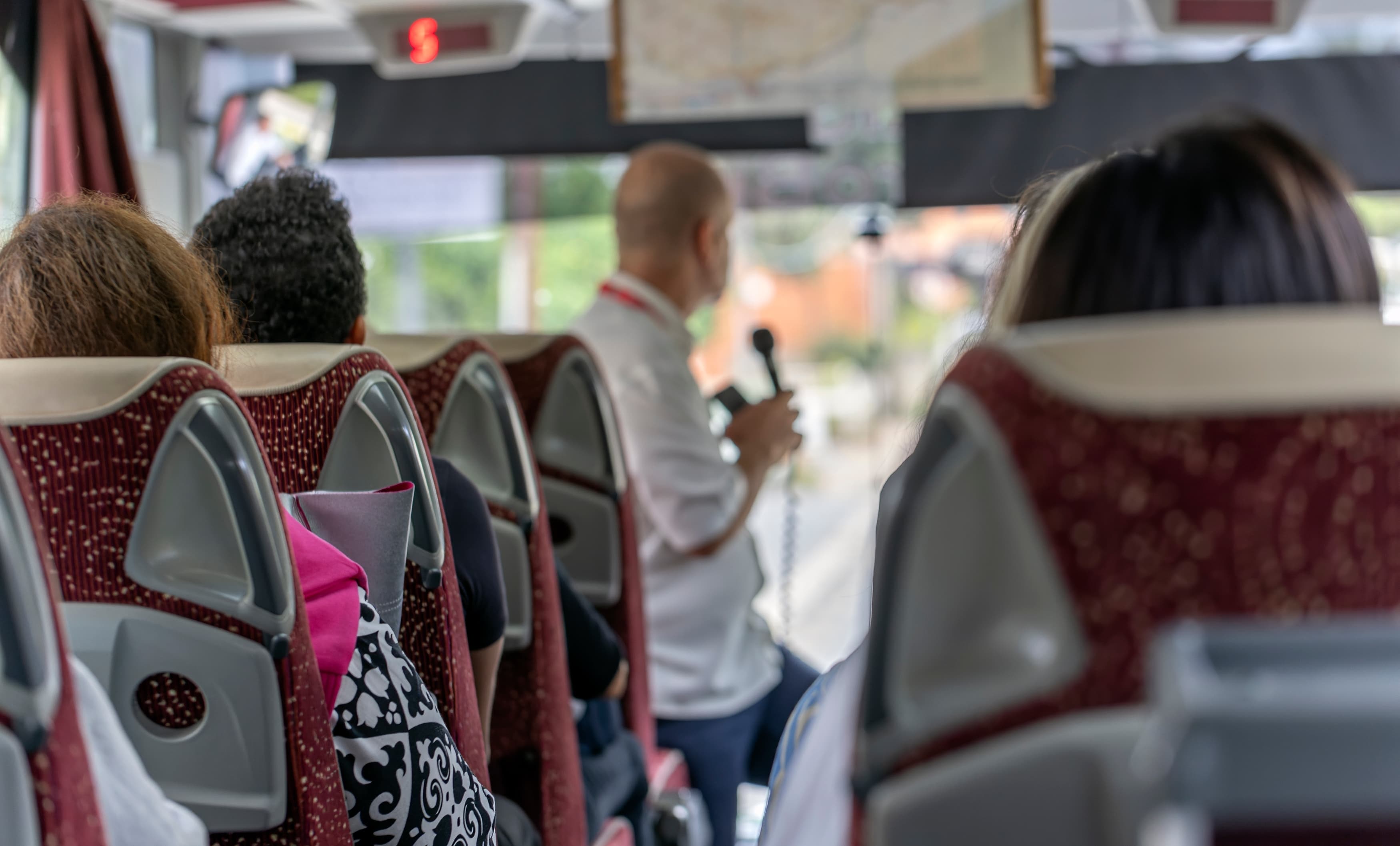 Guide assisting tourists on a bus